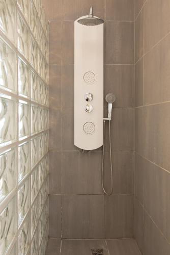 un baño con ducha con cabezal de ducha en Studio Le Lavandou, en De Panne