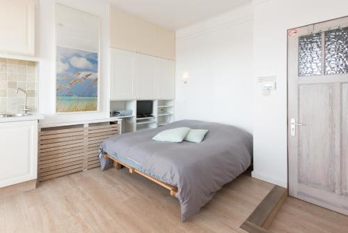 Un dormitorio con una cama y una cocina. en Studio Le Lavandou, en De Panne