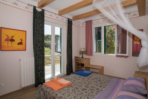 a bedroom with a bed and two windows at B&B La casa dei gelsi in Loano