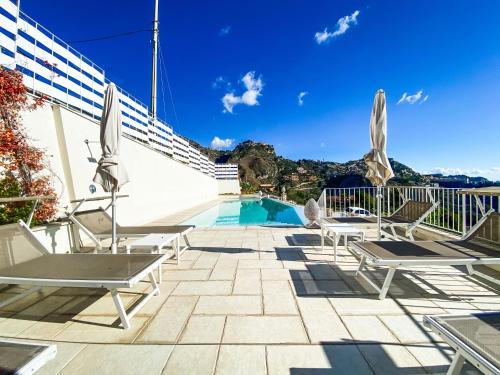 a patio with chairs and a swimming pool at Sciccosa Guest House in Taormina
