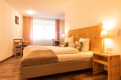 a hotel room with a large bed and a table at Pitztal Living Apartments in Jerzens