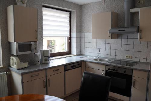 a kitchen with a sink and a stove top oven at Ferienwohnung an der Mainschleuße in Harrbach