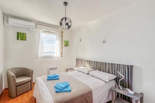 een slaapkamer met een bed, een stoel en een raam bij Cappella in Ajaccio