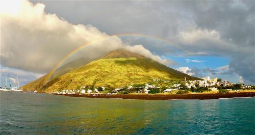 a rainbow over a small island in the water at La Casa di Nonna Ida in Stromboli