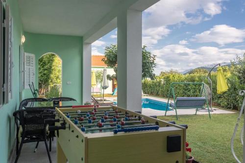 una gran mesa de futbolín en un patio con piscina en Holiday Home Sunrise, en Kraj