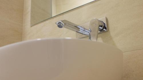 aseo blanco en el baño con espejo en Poiana Ski Residence Apartment 5 en Poiana Brasov