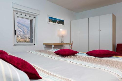 een slaapkamer met twee bedden met rode kussens erop bij Torbole Holiday House Appartamento con giardino in Nago-Torbole