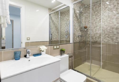 y baño con lavabo y ducha acristalada. en MIT House Avenida America Confort XIII en Madrid, en Madrid