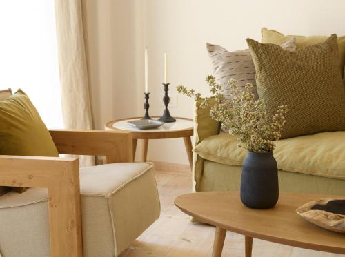 a living room with a vase of flowers on a table at Vencia Boutique Hotel in Mýkonos City