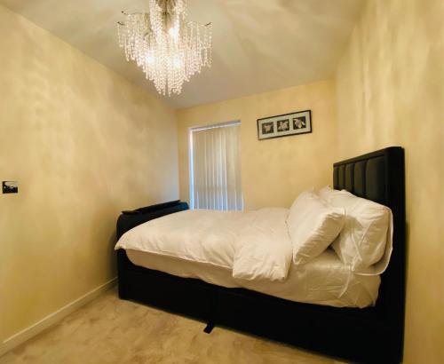 a bedroom with a large bed with a chandelier at Birmingham Guesthouse in Birmingham