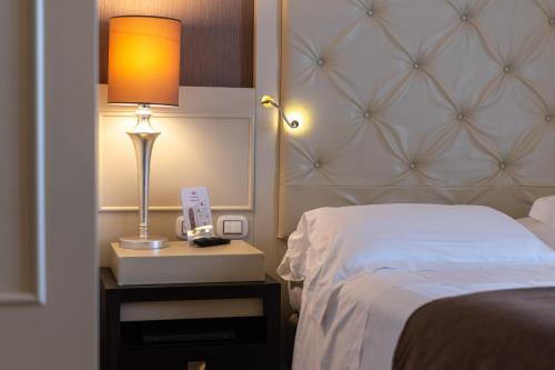 a bedroom with a bed and a lamp on a night stand at Best Western Plus Hotel Perla Del Porto in Catanzaro Lido