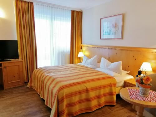 a hotel room with a bed and a television at Hotel Sportalm in Gerlos