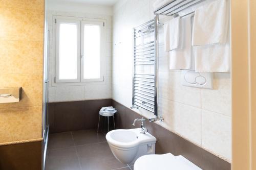 a bathroom with a toilet and a window at Best Western Plus Hotel Perla Del Porto in Catanzaro Lido