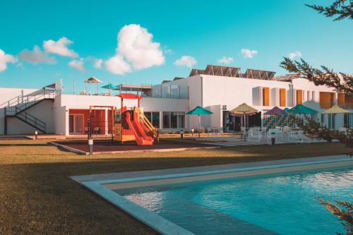 ein Resort mit einem Pool und einem Spielplatz in der Unterkunft RIDE Surf Resort & Spa in Peniche