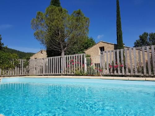 ein Zaun und ein Pool vor einem Haus in der Unterkunft Chambres d'Hôtes Aux Tournesols in Malaucène