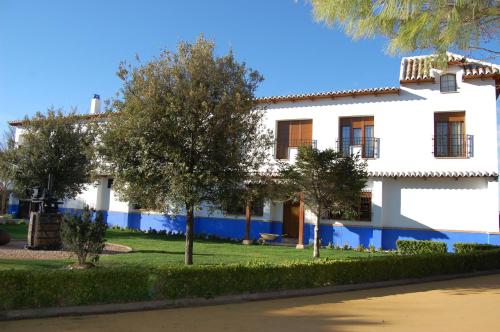 a white building with trees in front of it at Hotel El Cortijo de Daimiel in Daimiel