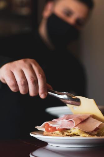 a person eating a plate of food with a fork at Best Western Plus Hotel Perla Del Porto in Catanzaro Lido
