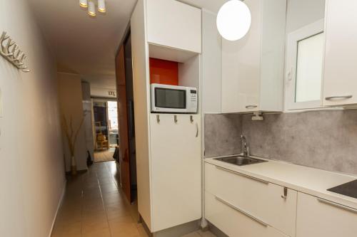 拉斯帕爾馬斯的住宿－Canteras Little Gem，厨房配有白色橱柜和微波炉