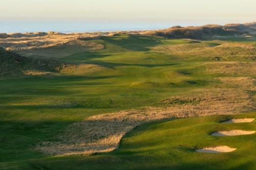 an aerial view of a golf course with the ocean in the background at Grand Hotel Belle Vue in De Haan