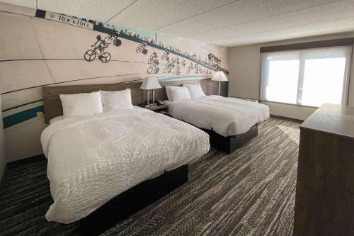 a hotel room with two beds and a window at Clarion Pointe Near University in Rock Hill