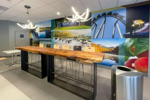 a large wooden counter in a room with a mural at Clarion Pointe Near University in Rock Hill