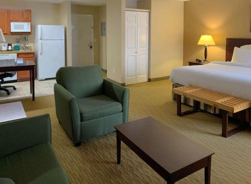 Habitación de hotel con cama, silla y mesa en MainStay Suites Addison - Dallas, en Addison