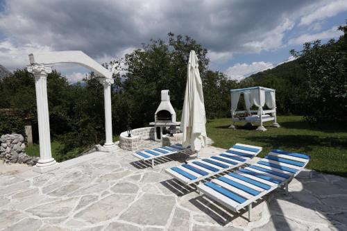 two lounge chairs and an umbrella next to a fountain at Villa D'amore Montenegro in Donji Morinj