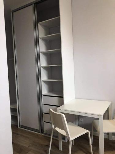a desk and chairs in a room with a closet at Hostelik Przy Przystanku in Gryfino