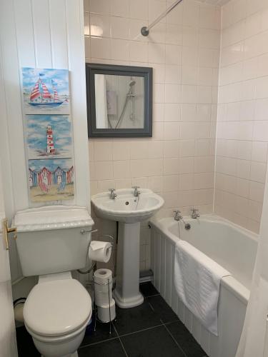 a bathroom with a toilet and a sink and a tub at Stay Seaton Delaval in Seaton Delaval