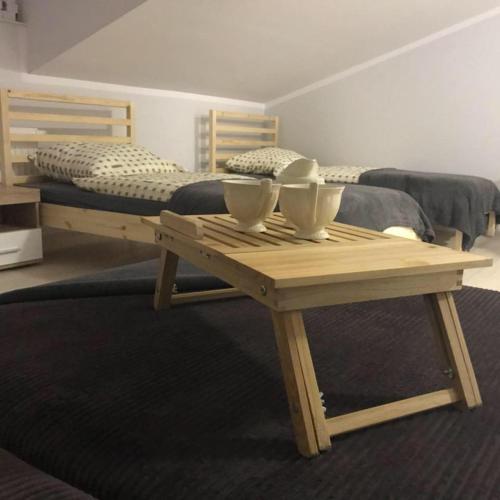 a wooden table with two bowls on top of a bed at Hostelik Przy Przystanku in Gryfino