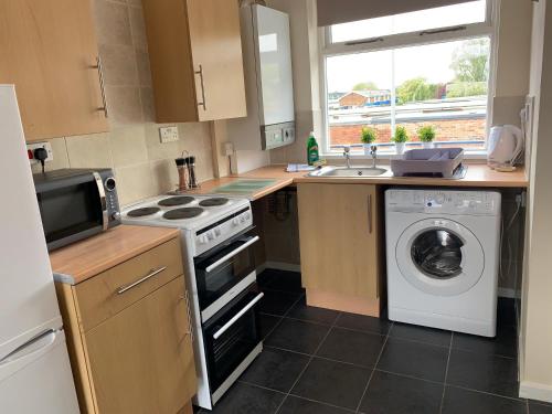 a kitchen with a stove and a washing machine at Stay Seaton Delaval in Seaton Delaval