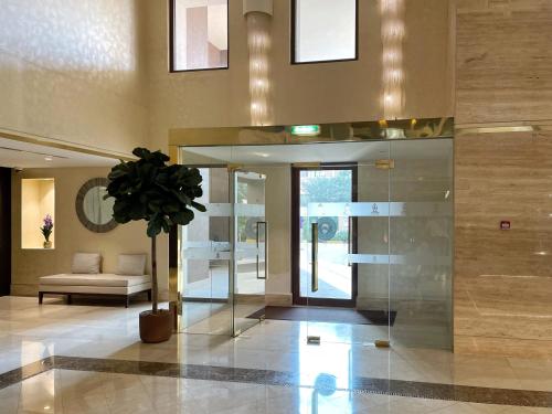 a lobby with a couch and a potted plant at Luxury Apartments at Balqis Residence in Dubai