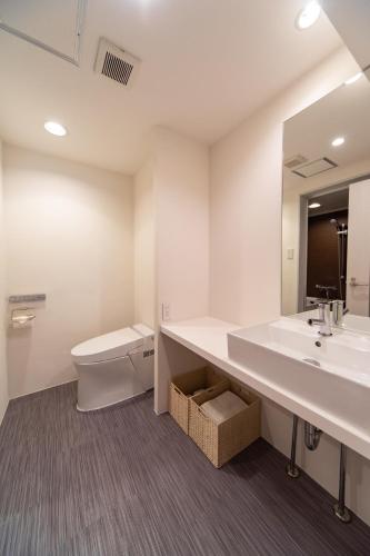 a bathroom with a toilet and a sink and a mirror at NIYS apartments 08 type in Tokyo