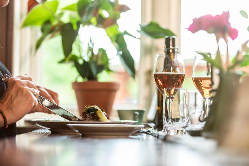 Una mesa con un plato de comida y una copa de vino. en Löfwings B&B, en Broddetorp