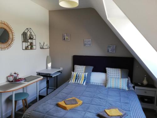 - une chambre avec un lit bleu et un bureau dans l'établissement 1 chambre d'hôte entre terre et mer, à Quimperlé