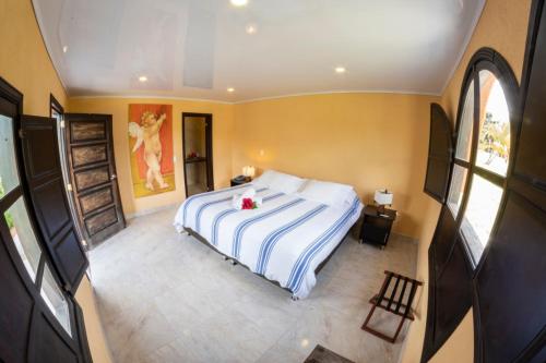 a bedroom with a bed with a white and blue blanket at San Agustin Internacional Hotel in San Agustín
