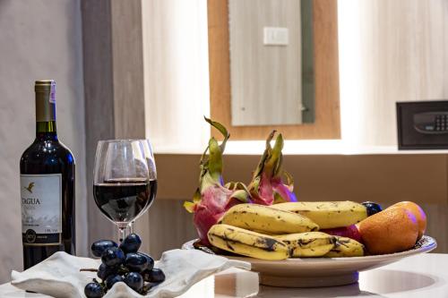 a bowl of fruit and a glass of wine on a table at Arushi Boutique Hotel in Kathmandu
