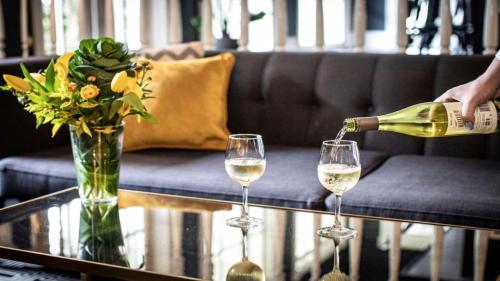 a person pouring wine into two glasses on a table at voco The Tiger Hotel, Columbia, MO by IHG in Columbia