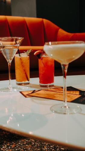a table with three cocktails on a table at voco The Tiger Hotel, Columbia, MO by IHG in Columbia