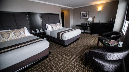 a hotel room with two beds and a chair at voco The Tiger Hotel, Columbia, MO by IHG in Columbia