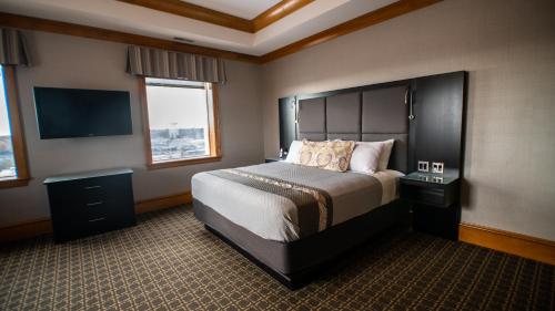 a bedroom with a large bed and a flat screen tv at voco The Tiger Hotel, Columbia, MO, an IHG Hotel in Columbia