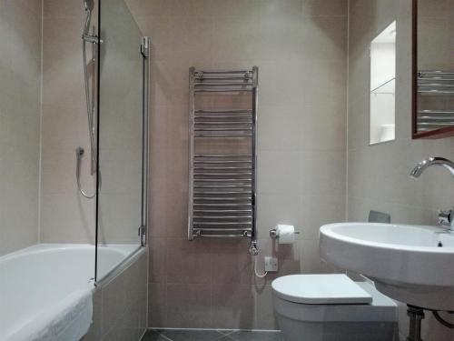 een badkamer met een wastafel, een toilet en een douche bij Barbican Serviced Apartments in Londen