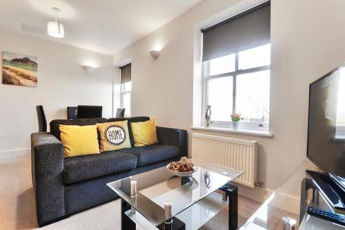 een woonkamer met een bank en een tv bij Sapphire Serviced Apartment in Chelmsford