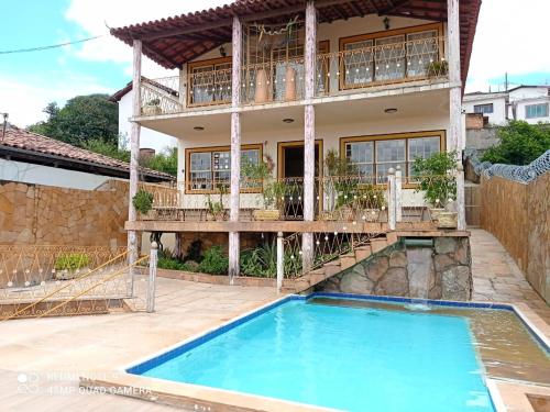 a house with a swimming pool in front of a house at Hotel Montanhas de Minas in Diamantina