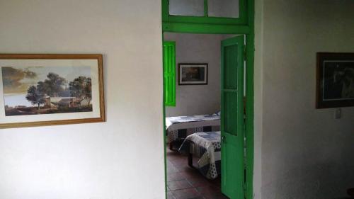 um quarto com uma porta verde e um quarto com uma cama em Don Luis Bueno em Carmen de Areco