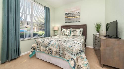 a bedroom with a bed and a television and a window at 5 Star Townhome on Windsor Hills Resort with Large Private Pool, Orlando Townhome 4922 in Orlando