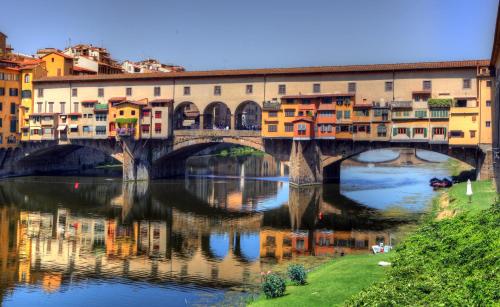 a bridge over a river with houses and buildings at Hotel Abaco in Florence