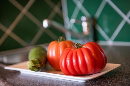 a plate of tomatoes and other vegetables on a table at Die WUNDER s Ferienpension in Pörtschach am Wörthersee