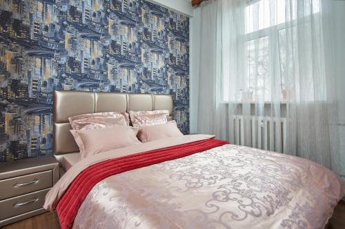 1 dormitorio con 1 cama con papel pintado azul y blanco en Studiominsk Apartments, en Minsk