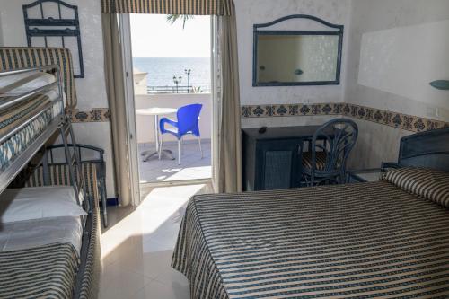 a bedroom with two beds and a fireplace with a view of the ocean at Casthotels Baia delle Sirene in Forio d'Ischia